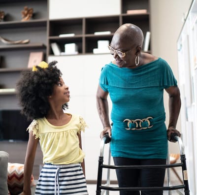 An elderly woman interacting with a young girl indoors.