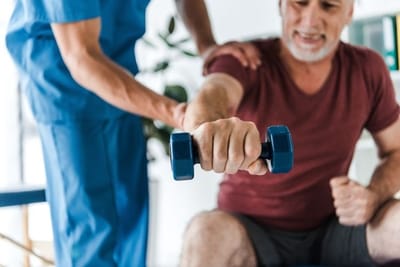 Staff assisting a resident with physical therapy