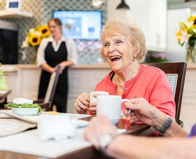 Residents enjoying a meal in a cheerful dining area.