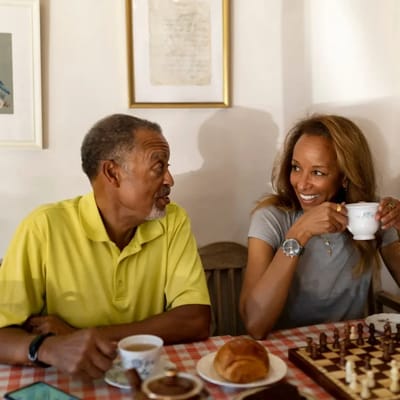 Two residents enjoying tea and a chess game.