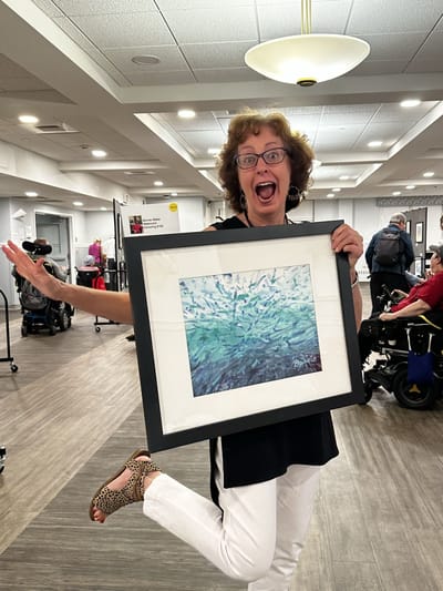 Staff member celebrating with artwork in a common area