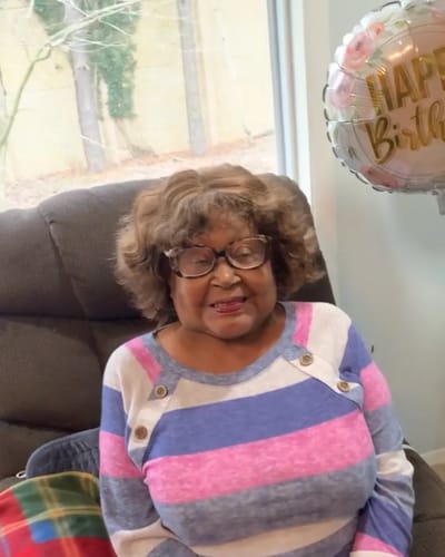 Resident celebrating a birthday with a balloon.