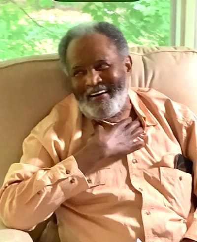 Elderly man laughing in a cozy chair