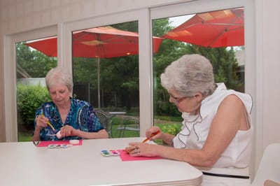 Two residents engaging in an art activity indoors.