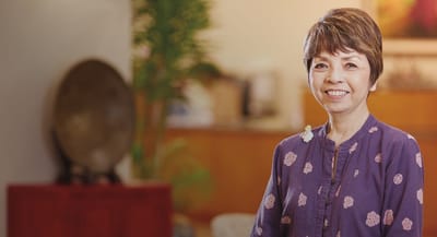 Resident smiling in a welcoming interior setting.