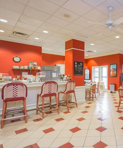 Bright dining area with red walls and bar stools
