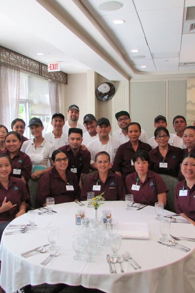 Staff gathered around a table in the dining area.