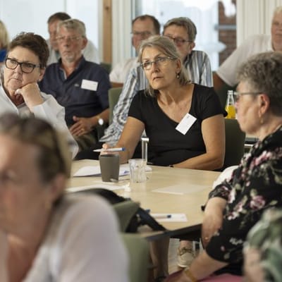 Residents and staff engaged in a group discussion.