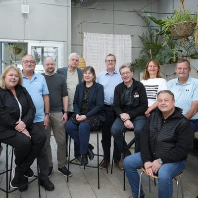 Group of people smiling in a communal space.