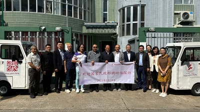 Group of people posing with a banner outside