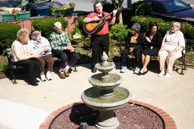 Residents enjoying music by the fountain outdoors.
