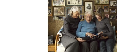Three women sharing a moment looking at photos.