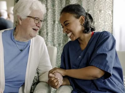 Staff member engaged with a resident, smiling.