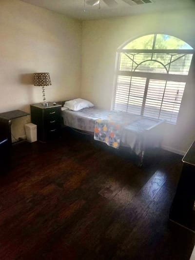 A simple private resident room with a window and bed
