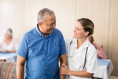 Caregiver smiling with a resident in a common area