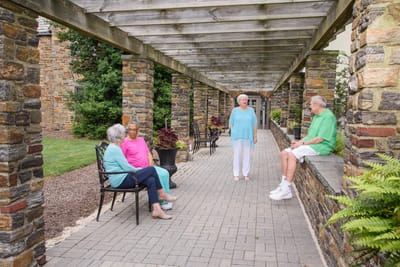 Residents enjoying time outdoors in a shaded walkway