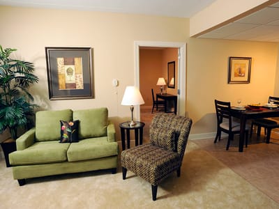 Cozy living room with green sofa and dining area