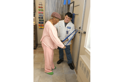 A resident participating in therapy with staff support