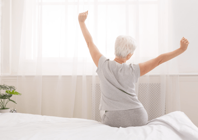 Elderly woman stretching in a bright, airy room