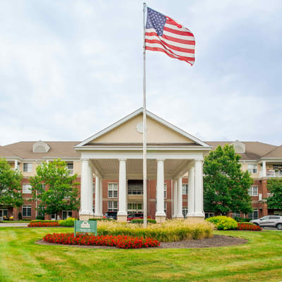 Exterior view of Westminster Village North with flag and landscaping
