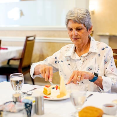 A resident enjoying dessert in the dining room