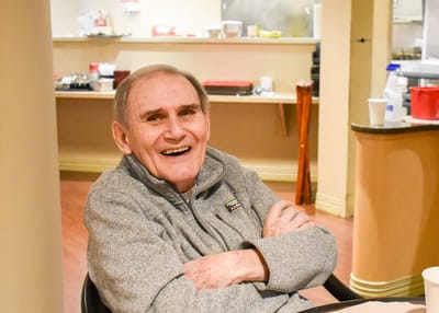 Elderly man smiling in a dining area