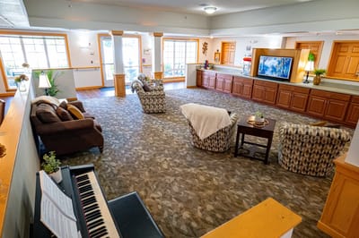 Bright common area with seating and piano