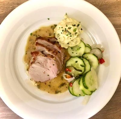 Plate of food with pork and vegetables serving