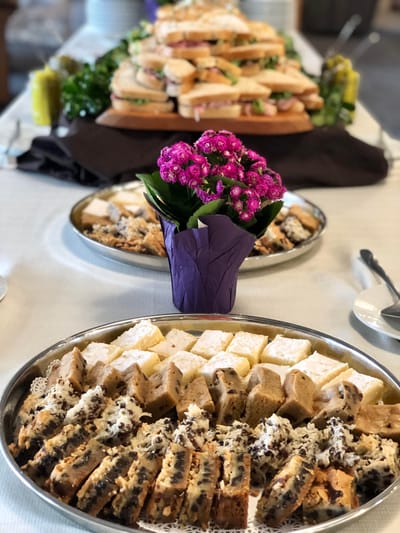 A platter of assorted treats with sandwiches in the background
