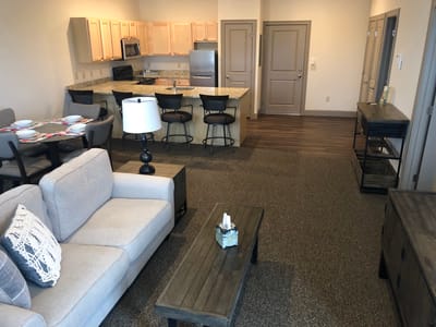 Spacious living room area with kitchen in senior living unit