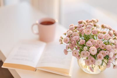 A book and a flower vase with tea.