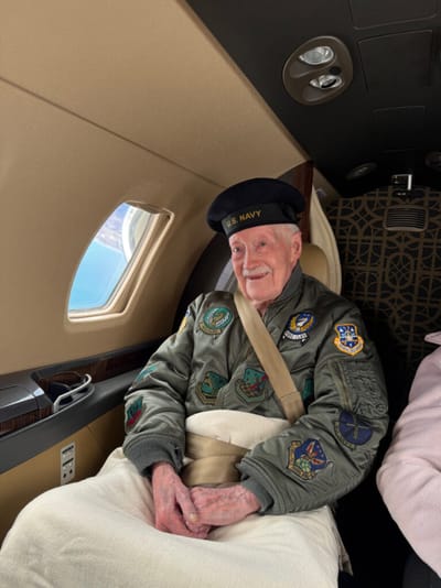 Elderly man in military attire inside an aircraft