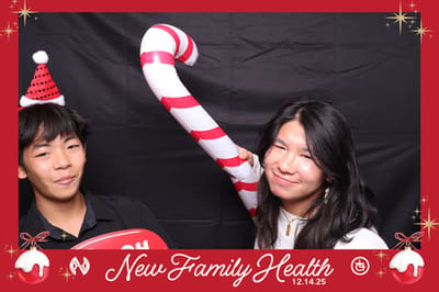 Two young people posing with a candy cane