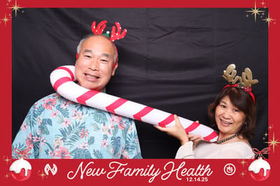 Two people in festive attire holding a candy cane.