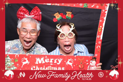 Two seniors wearing festive hats and glasses posing joyfully.