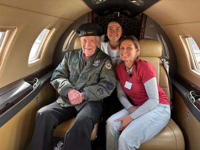 Veteran with staff members in a small aircraft