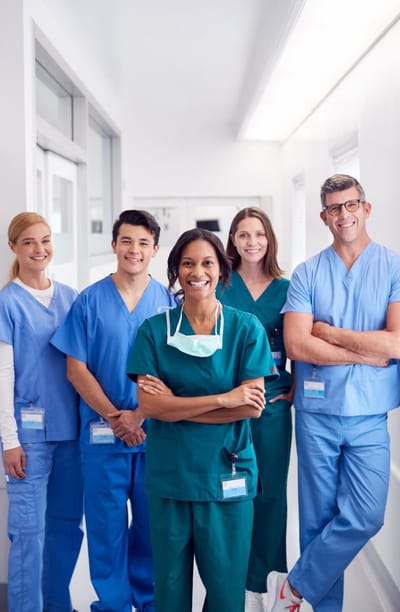 Group of smiling healthcare professionals in scrubs.