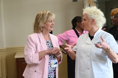 Two women engaged in conversation in a common area.