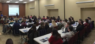 Large group meeting in a facility interior space.