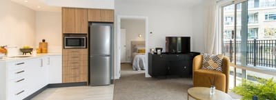 Modern kitchen and living area in assisted living room.
