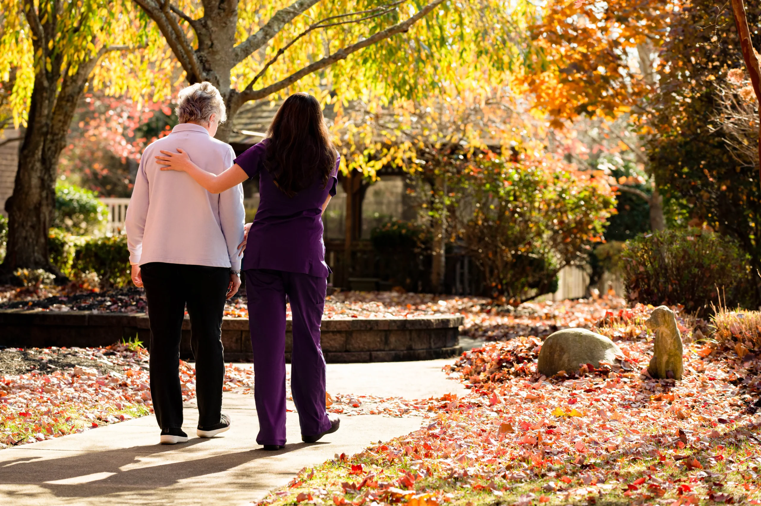 A staff member assisting a resident outdoors.