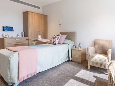 Cozy private resident room with a bed and chair