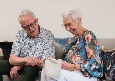 Two seniors engaged in a cheerful conversation.