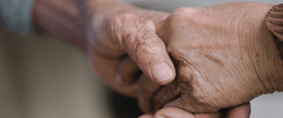 Two hands holding each other warmly.
