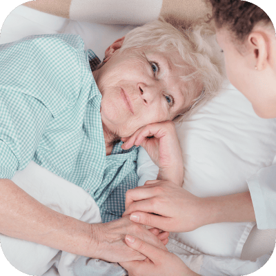 A caregiver holding hands with an elderly resident