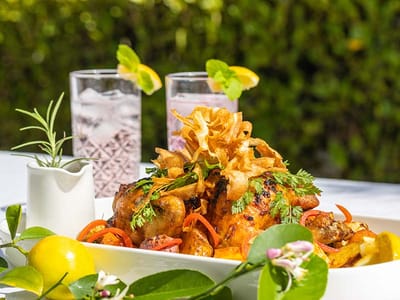 Plated food with drinks in an outdoor setting.