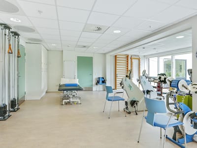 Rehabilitation room with equipment and exercise area.