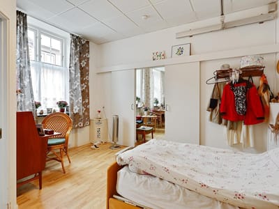 Cozy resident room with bed and seating area.