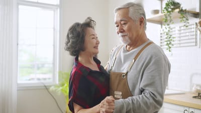 Senior couple dancing in a bright indoor space.