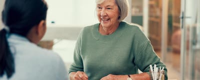 Senior woman smiling while interacting with another person